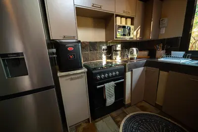 a small kitchen with a stove and a refrigerator at Bushveld Jewel - Close to Kruger in Hoedspruit