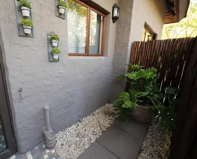 a backyard with plants and a fence and a house at Bushveld Jewel - Close to Kruger in Hoedspruit