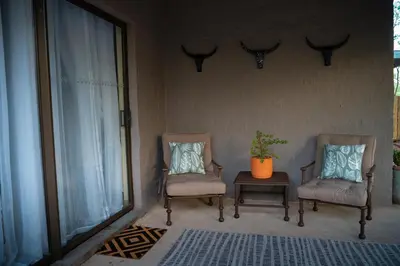 two chairs and a table with a plant on a porch at Bushveld Jewel - Close to Kruger in Hoedspruit