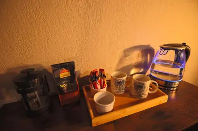 a wooden table with cups and a coffee maker at Bushveld Jewel - Close to Kruger in Hoedspruit