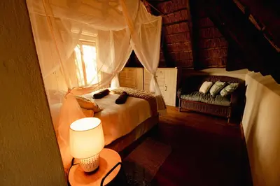 a bedroom with a bed and a window and a couch at Bushveld Jewel - Close to Kruger in Hoedspruit