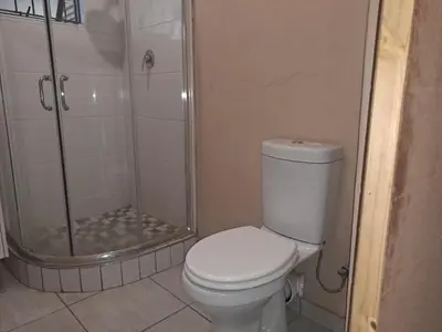 a bathroom with a toilet and a shower at Cozy Airport Stay in Kempton Park
