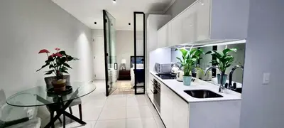 a kitchen with a glass table and a sink at Xquisite Ellipse Apartment in Midrand