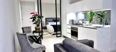 a kitchen with a couch and a table in a room at Xquisite Ellipse Apartment in Midrand