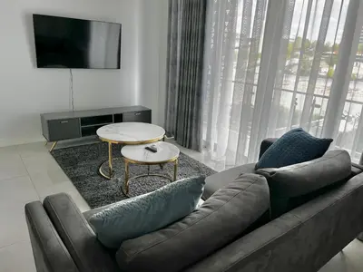 a living room with a couch and a table at Xquisite Ellipse Apartment in Midrand