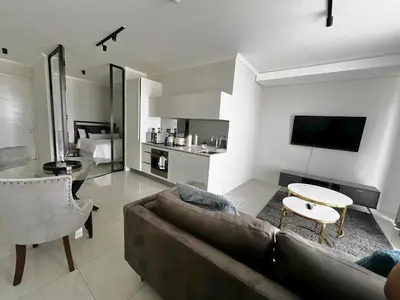 a living room with a couch and a table at Xquisite Ellipse Apartment in Midrand