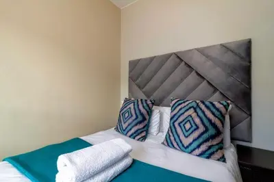 a bedroom with a bed with two pillows on it at The Waterfallcity Charm next to Mall of Africa in Midrand