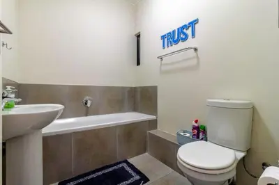 a bathroom with a toilet and a sink at The Waterfallcity Charm next to Mall of Africa in Midrand