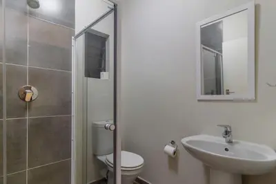 a bathroom with a toilet and a sink and a shower at The Waterfallcity Charm next to Mall of Africa in Midrand