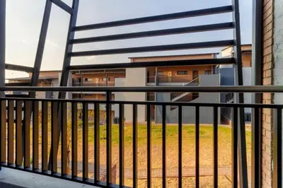a black metal fence with a building in the background at The Waterfallcity Charm next to Mall of Africa in Midrand