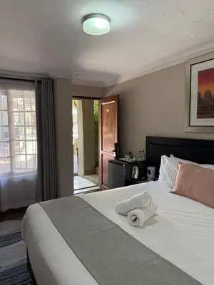 a hotel room with a bed with a towel on it at The Eden Boulders Hotel and Resort Midrand in Midrand