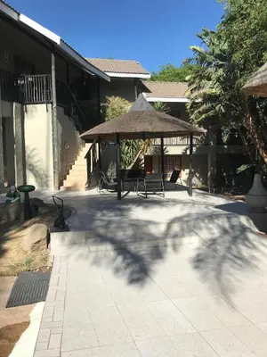a patio with a gazebo and a tree at The Eden Boulders Hotel and Resort Midrand in Midrand