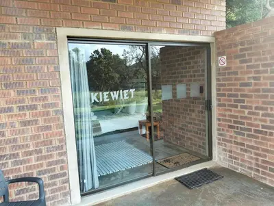 a large glass window in a brick wall at Kataluma in Pretoria