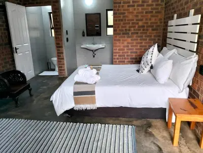 a bedroom with a large white bed with a sink at Kataluma in Pretoria