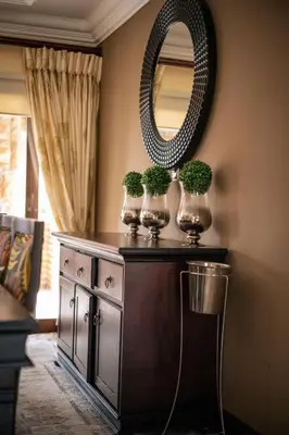 a table with three plants on it with a mirror at White River Country Estate - Self Catering - AMH Home in White River