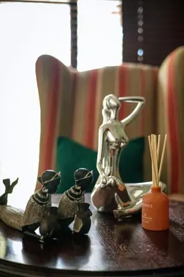 a table with a statue of a woman and figurines on it at White River Country Estate - Self Catering - AMH Home in White River