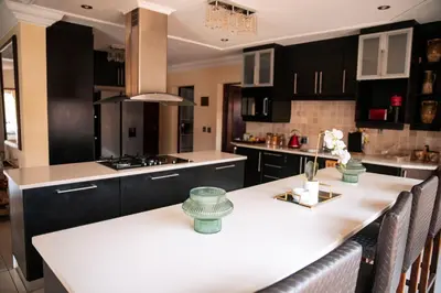 a kitchen with black cabinets and a white counter top at White River Country Estate - Self Catering - AMH Home in White River