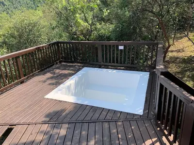 a swimming pool on a deck with a wooden deck at Schoemanskloof, Mpumalanga - Clancy Forest Lodge in Rietvlei