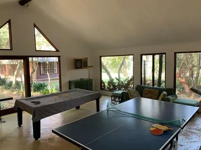 a living room with a ping pong table in it at Schoemanskloof, Mpumalanga - Clancy Forest Lodge in Rietvlei