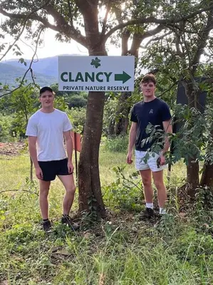 two men standing next to a tree in front of a sign at Schoemanskloof, Mpumalanga - Clancy Forest Lodge in Rietvlei