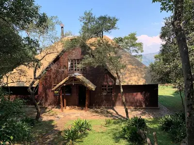 an old brick house with a grass roof at Schoemanskloof, Mpumalanga - Clancy Forest Lodge in Rietvlei