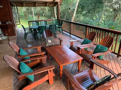 a deck with wooden tables and chairs on a porch at Schoemanskloof, Mpumalanga - Clancy Forest Lodge in Rietvlei