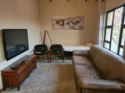 a living room with a couch and a tv and a bed at Stay@Walter in Pretoria