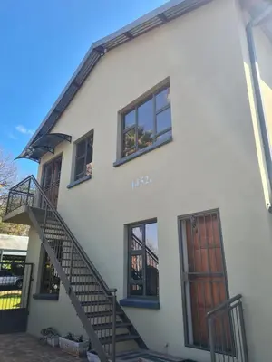 a white house with a staircase and windows at Stay@Walter in Pretoria