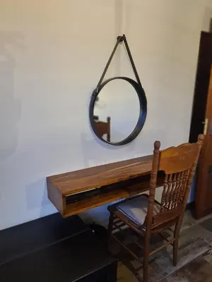 a mirror hanging above a wooden desk with a chair at Stay@Walter in Pretoria