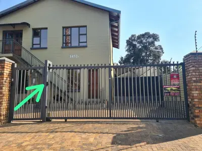 a gate with a green x on it in front of a house at Stay@Walter in Pretoria