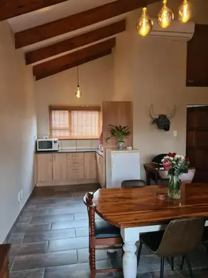 a kitchen and dining room with a wooden table at Stay@Walter in Pretoria