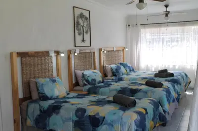 a room with four beds and a couch at Bush Lilly Cottage in Hazyview