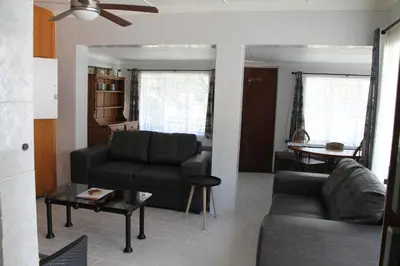 a living room with a couch and a table at Bush Lilly Cottage in Hazyview