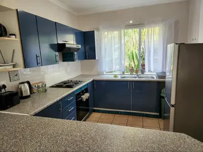 a kitchen with blue cabinets and a sink and a window at The Grace in Pretoria