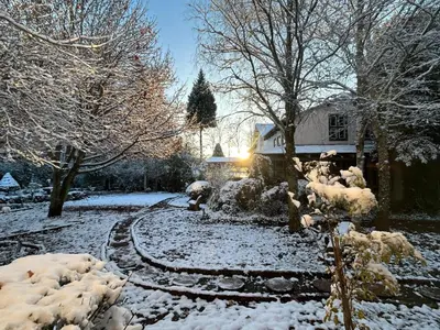 a yard covered in snow with a house at Highland Rose Country House Spa in Dullstroom