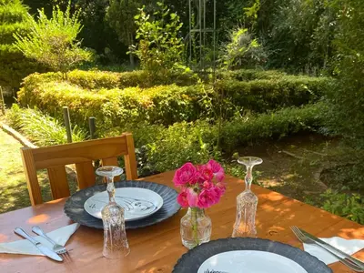 a wooden table with plates and vases on it at Highland Rose Country House Spa in Dullstroom