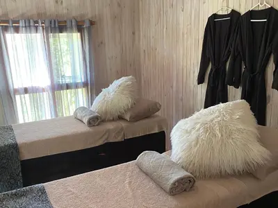 a bedroom with two beds with white pillows on them at Highland Rose Country House Spa in Dullstroom