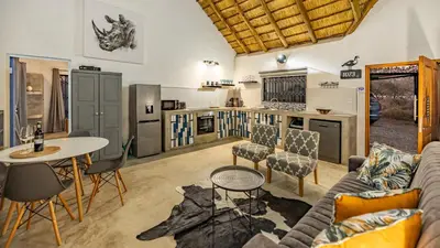 a living room with a couch and a table at Blue Goose Bush Retreat in Marloth Park