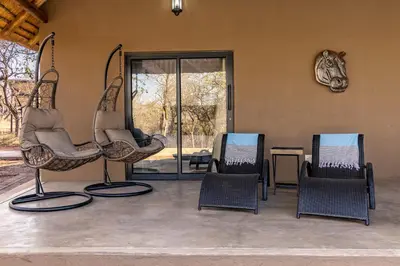 a group of chairs sitting in a room at Blue Goose Bush Retreat in Marloth Park