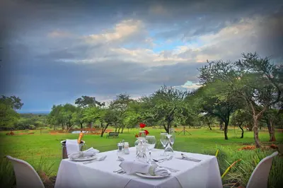a table with a white table cloth on a field at Itaga Luxury Private Game Lodge in Bela-Bela