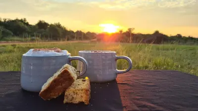 two cups of bread on a table with the sunset in the background at Itaga Luxury Private Game Lodge in Bela-Bela