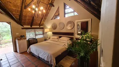 a bedroom with a bed in a room with windows at Itaga Luxury Private Game Lodge in Bela-Bela