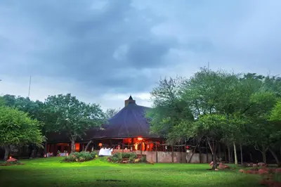 a large building with a thatched roof in a park at Itaga Luxury Private Game Lodge in Bela-Bela