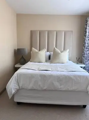 a bedroom with a white bed with white sheets and pillows at Iyana Place in Midrand