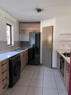 a large kitchen with a washer and dryer in it at Iyana Place in Midrand