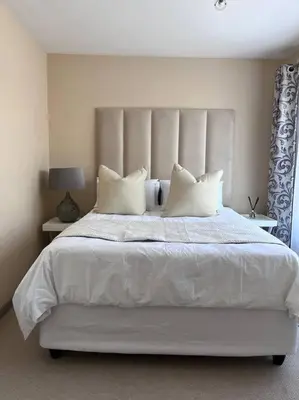 a bedroom with a white bed with white sheets and pillows at Iyana Place in Midrand