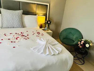 a bedroom with a white bed with flowers on it at Kings View Exclusive Villas (KVEV) in Petronella