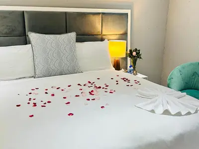 a bed with red hearts on it with a blue chair at Kings View Exclusive Villas (KVEV) in Petronella