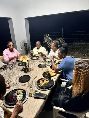 a group of people sitting around a table eating food at Kings View Exclusive Villas (KVEV) in Petronella