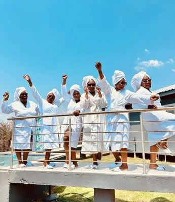 a group of women dressed in white standing on a bridge at Kings View Exclusive Villas (KVEV) in Petronella